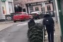 A police officer was seen dragging a town's stolen Christmas tree