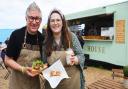 Gary Arlow and his daughter Joely Carter with loaded fries and a cake from their new venture Birdys Bakehouse at Blakeney Quay.