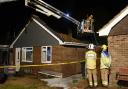 Fire fighters on the aerial platform putting out pockets of flames after a fire destroys a bungalow in Cathedral Drive, North Elmham. Picture: DENISE BRADLEY