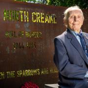 Bernie How sits in front of the North Creake memorial