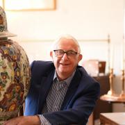 Mike Hicks, owner, at the Stalham Antiques Gallery, with a late 19th century polycrome delft vase