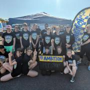 The 12-strong team of Alderman Peel High School pupils, led by Amanda Moffatt, at the Lotus factory test track in Hethel.