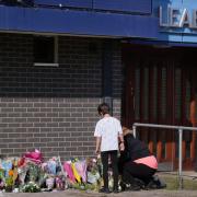 A person lays flowers at Leabank, Luton (PA)